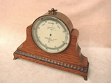 Late Victorian brass cased aneroid barometer  by Francis Darton with oak mantle stand.